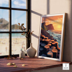 Giant's Causeway Wall Art Poster displayed on a shelf with a sunny beach view in the background.