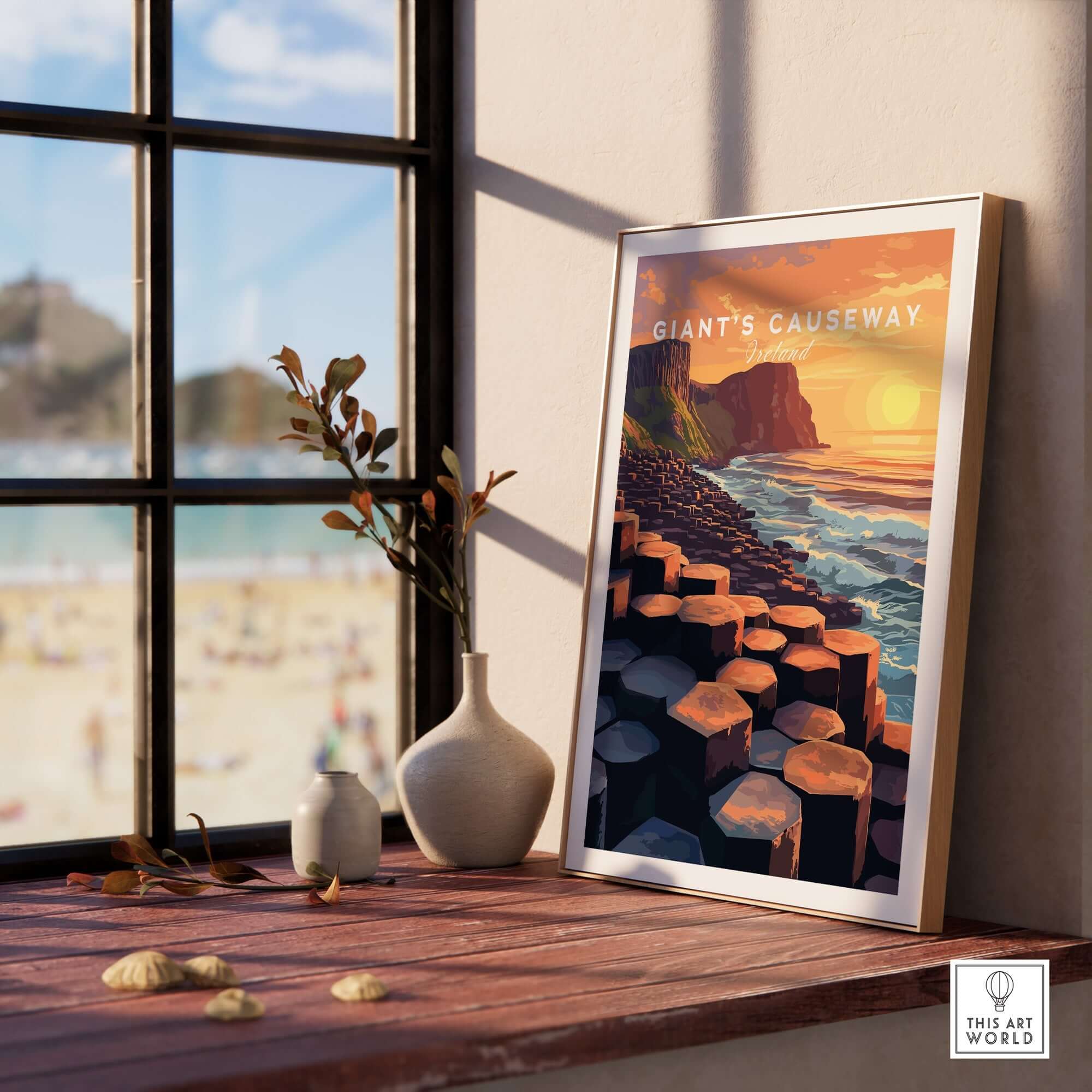 Giant's Causeway Wall Art Poster displayed on a shelf with a sunny beach view in the background.
