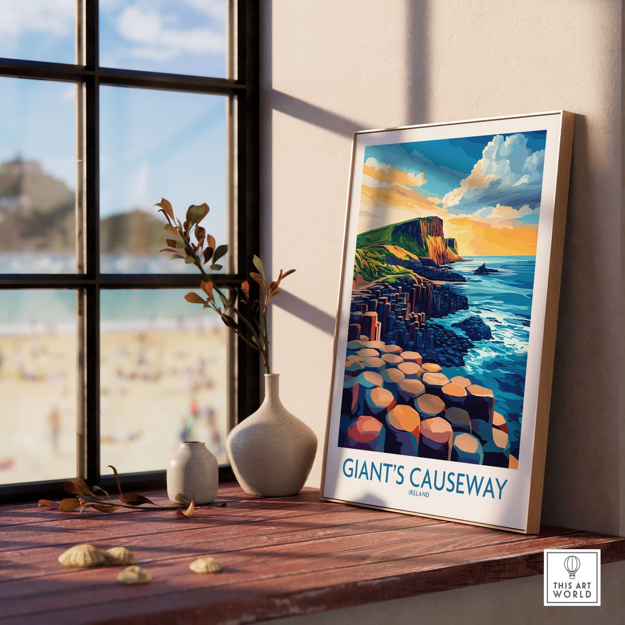 Giant's Causeway Wall Art Print displayed on a wooden table with a scenic view of the coastline and rocky formations.