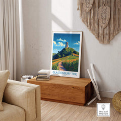 Glastonbury Tor Wall Art Print displayed in a cozy living room setting, showcasing its vibrant colors and scenic design.