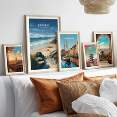 Godrevy Beach Poster - North Cornwall Coast Wall Decor displayed among other travel posters on a stylish couch.