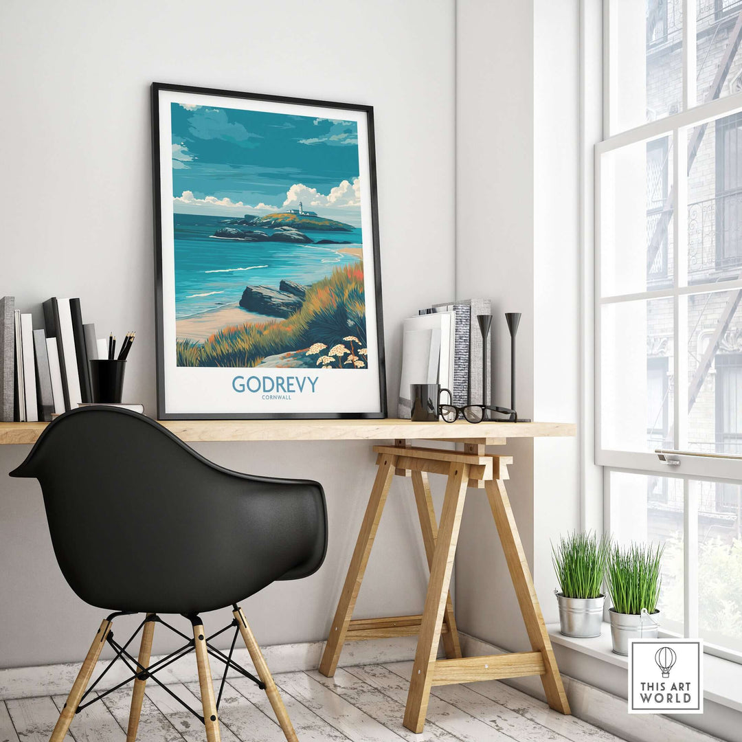 Godrevy poster displayed in a modern workspace, showcasing Cornwall's coastline and a serene beach scene.