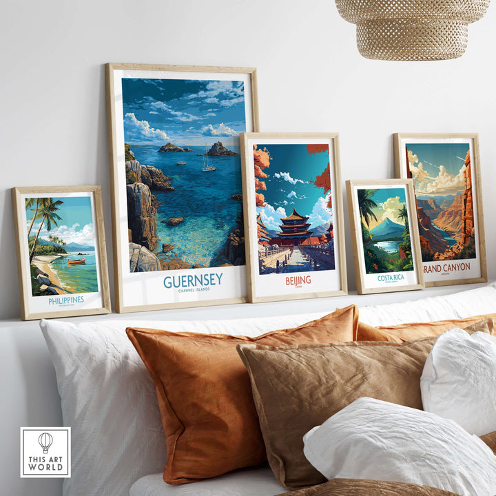 Guernsey Print Channel Islands Coast Art | Rocky Shore Sailing Poster displayed among other travel art prints on a sofa.