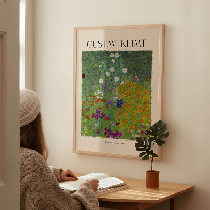 Gustav Klimt 1907 Flower Garden art print displayed on wall, person admiring vibrant floral design while reading.