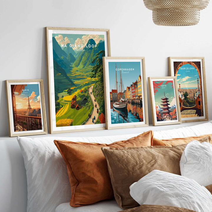 Framed travel posters featuring Ha Giang Loop, Copenhagen, and Barcelona, displayed above a cozy sofa with decorative pillows.
