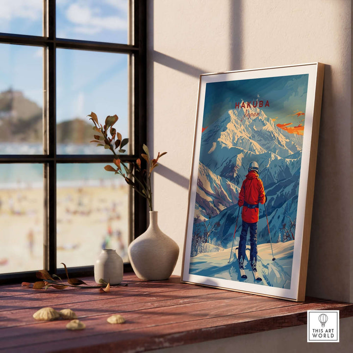 Hakuba Ski Poster displayed on a sunlit windowsill with a vase and scenic view, featuring a skier in red against a snowy mountain backdrop.