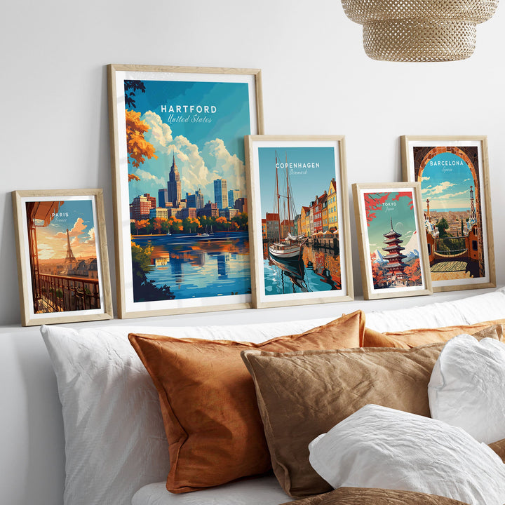 Stylish room with travel posters featuring Hartford, Copenhagen, and Barcelona skylines, framed above a cozy sofa.