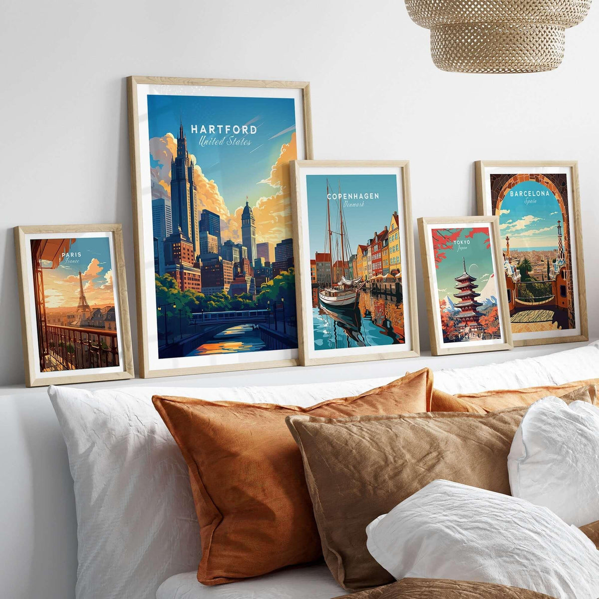 Hartford Travel Print displayed among other travel posters in a stylish bedroom setting with decorative pillows.