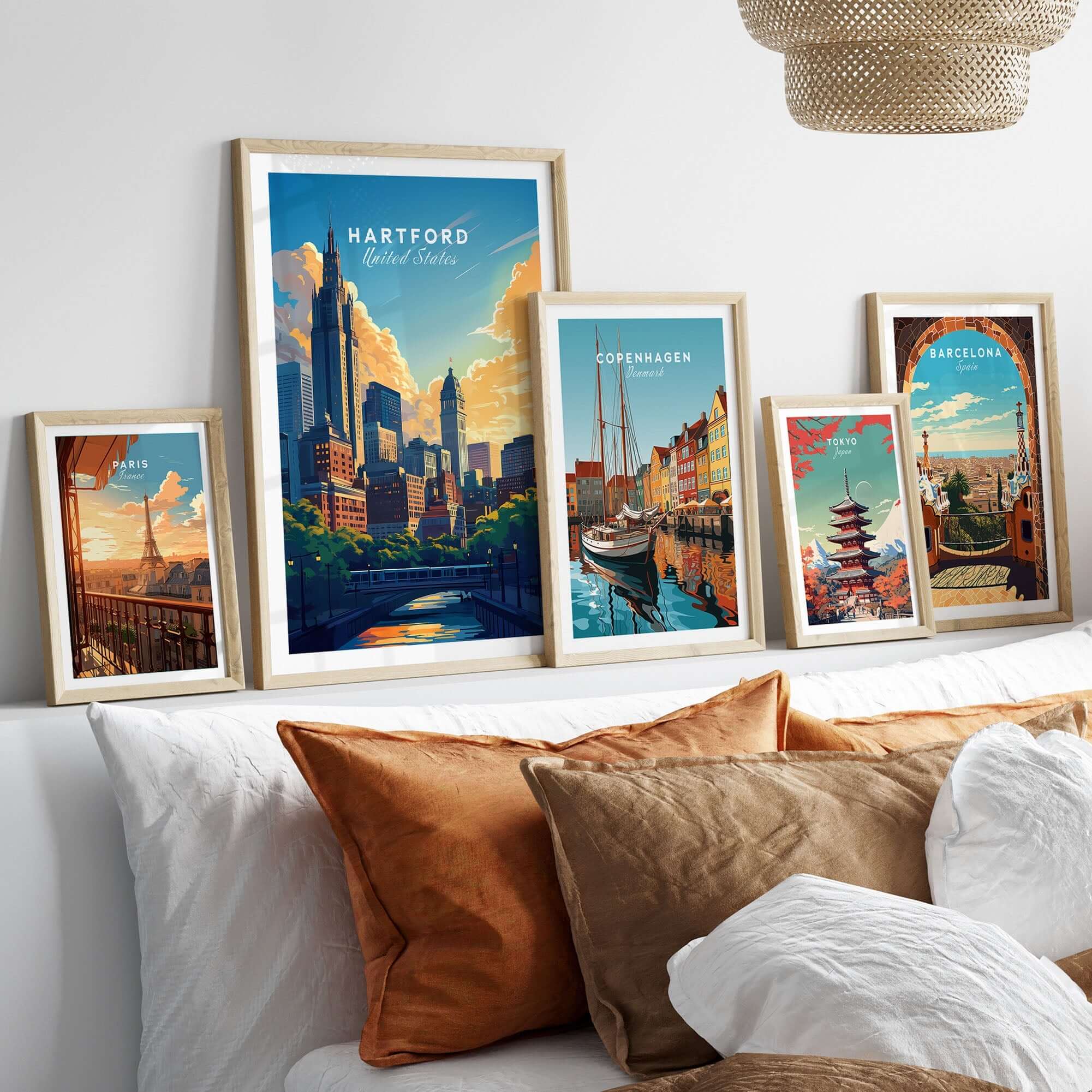 Hartford Travel Print displayed among other travel posters in a stylish bedroom setting with decorative pillows.
