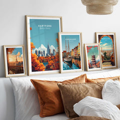 Hartford Wall Art displayed among travel posters on a stylish couch with decorative cushions.