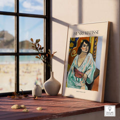 Matisse Poster - Algerian Woman 1909 Fauvist Wall Art Print displayed in a sunlit room with decorative vase and beach view.