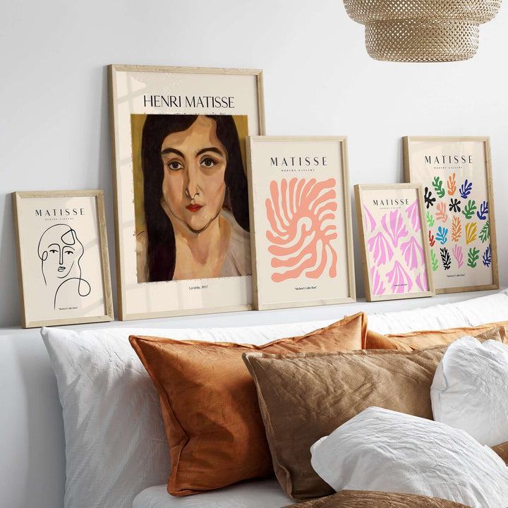 Henri Matisse art prints displayed on a wall above a bed, featuring portraits and abstract designs