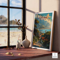Hermanus Art Print South Africa framed on a wooden table with ocean view, showcasing vibrant seaside landscape.