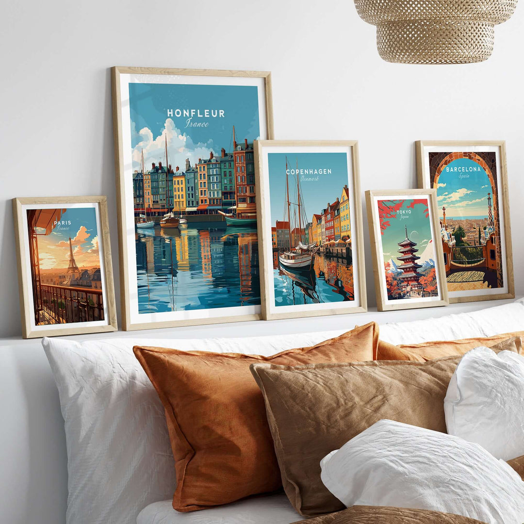 Framed Honfleur art print among travel posters, showcasing Normandy coastal decor on a stylish sofa.