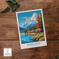 Interlaken Poster Switzerland featuring a train by a lake with mountains in the background, showcasing stunning landscape art.