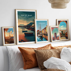 Isle of Islay Scotland Wall Art Print | Coastal Boats Travel Poster displayed among other framed travel posters on a couch.