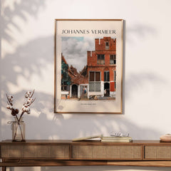 Johannes Vermeer The Little Street 1657 Delft Scene Dutch Golden Age Art Print framed on a wall above a wooden console.