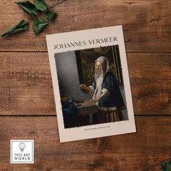 Johannes Vermeer Woman Holding a Balance 1662 Dutch Baroque Art Print Poster displayed on a wooden table.