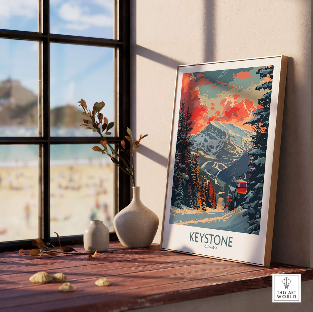 Keystone Colorado poster on a sunny windowsill with beach view, showcasing colorful mountain landscape and pine trees in a white frame.