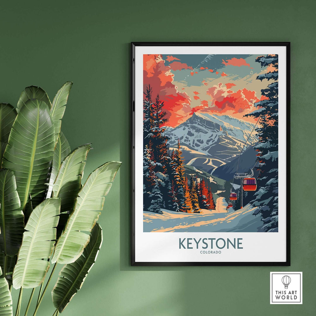 Keystone Colorado poster featuring a vibrant mountain landscape with snow and a colorful sky, framed on a green wall with plants.