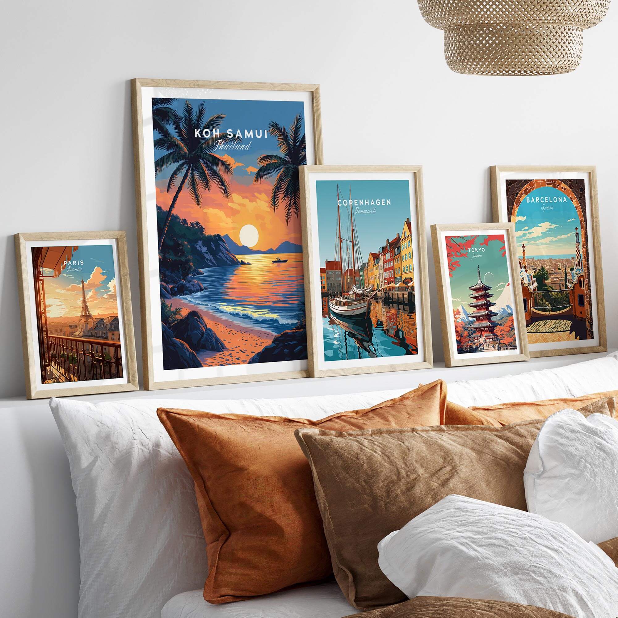 Koh Samui Thailand Travel Print and other travel posters displayed on a bed with decorative pillows.