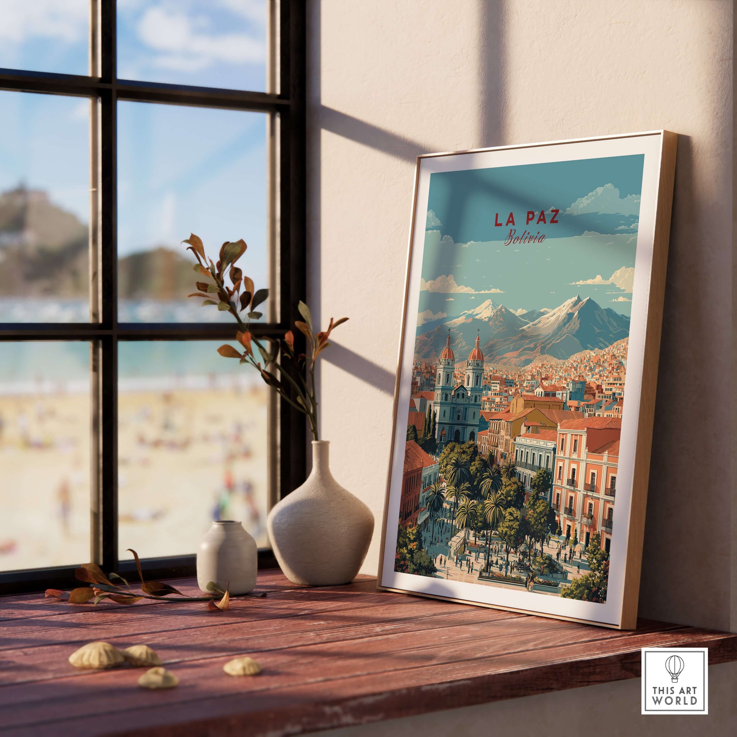La Paz Travel Print - Bolivia Wall Art displayed on a wooden table by a window with Andean mountains in the background.