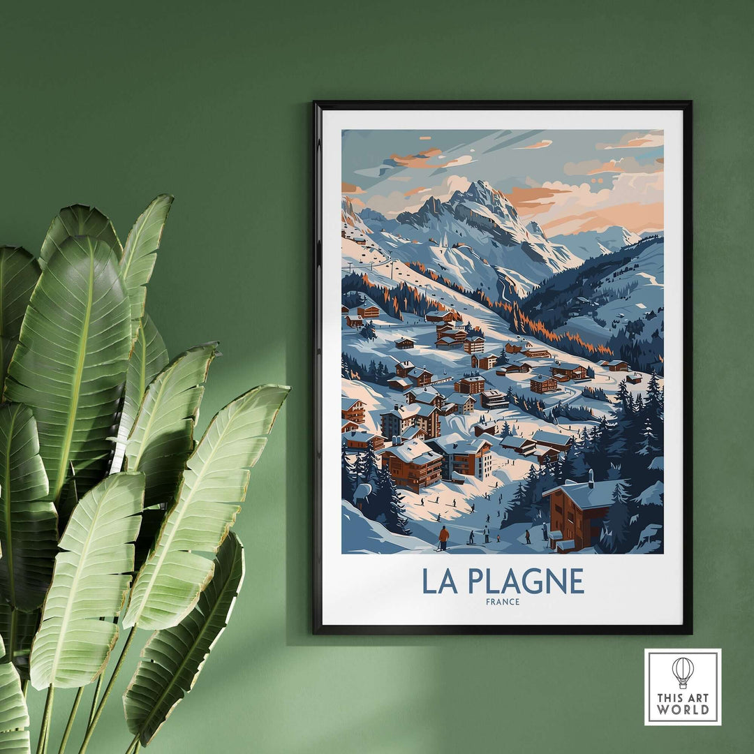 Wall art of La Plagne mountain village covered in snow, framed and hung on a green wall with a plant nearby.