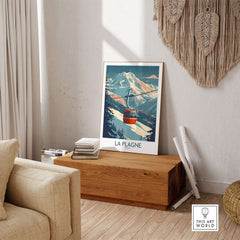 Ski-themed La Plagne wall art poster in cozy living room setting, featuring a scenic mountain cable car design.