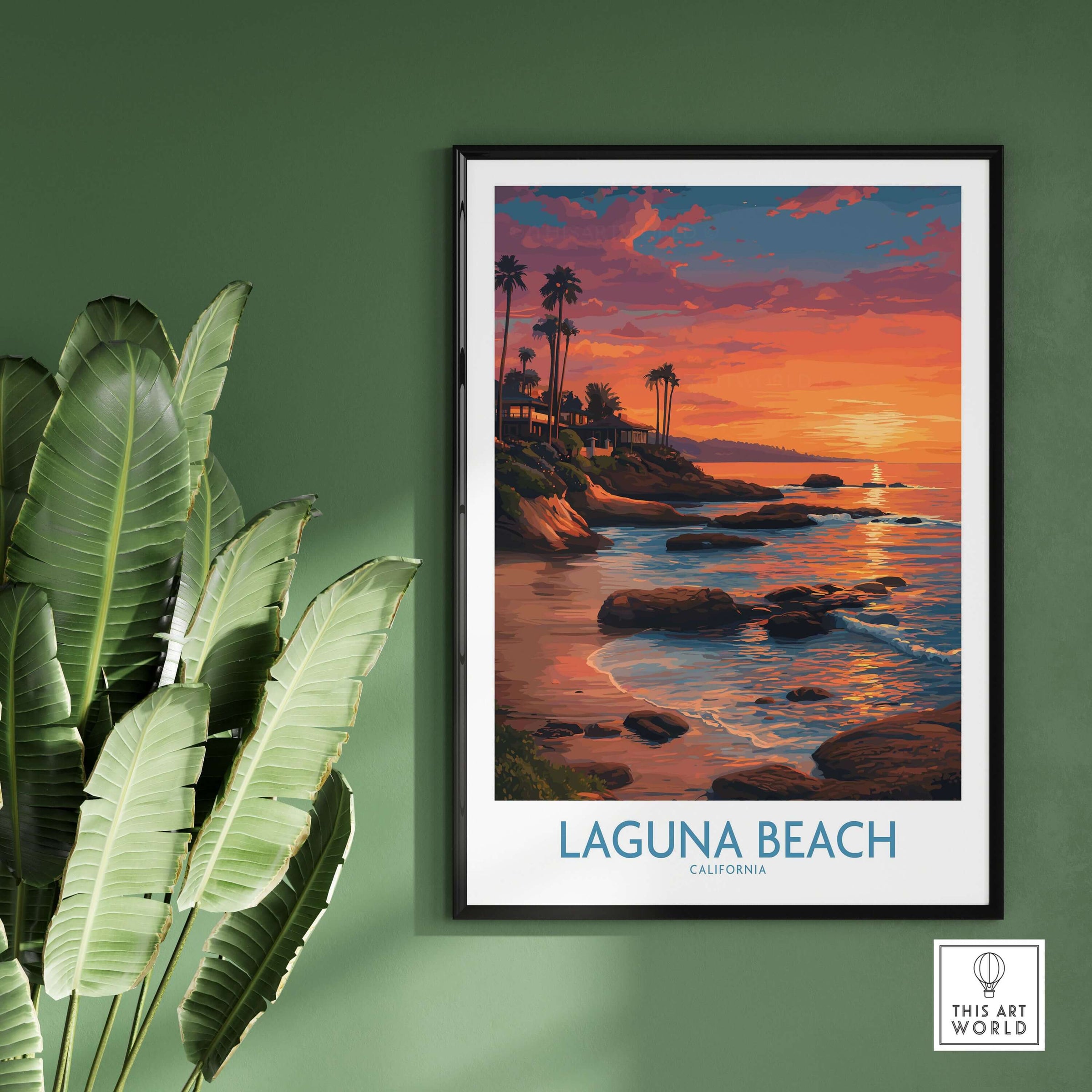 Laguna Beach California Sunset Art Print | Vibrant Coastal Poster framed on a green wall with palm leaves in the foreground.