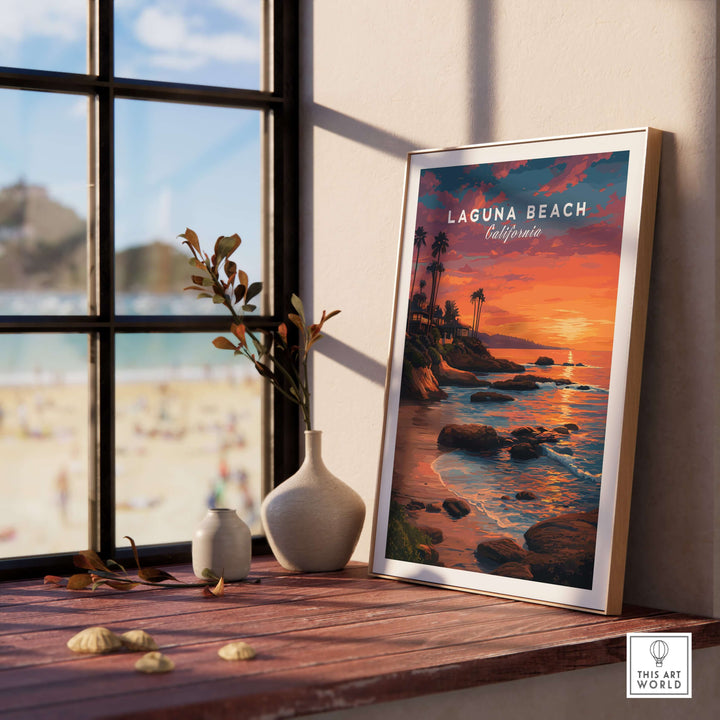 Laguna Beach Pacific Ocean Print displayed on a windowsill with a coastal view and sunset ambiance.
