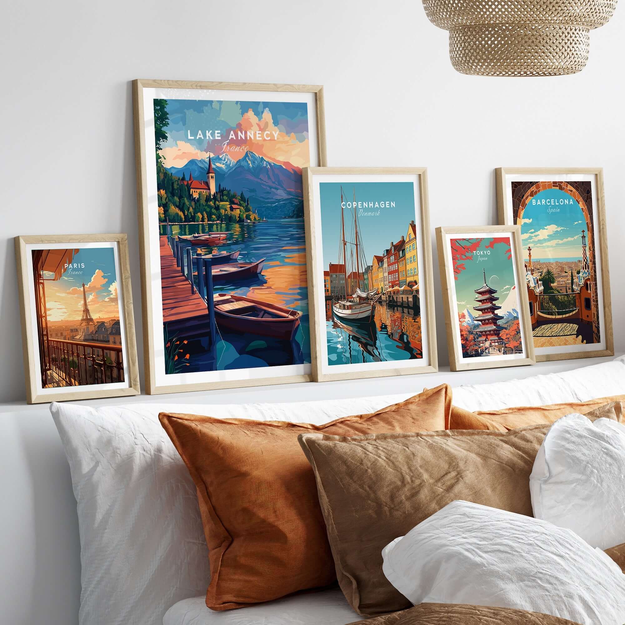 Lake Annecy Wall Art displayed among other travel-themed wall art on a cozy bed with pillows.