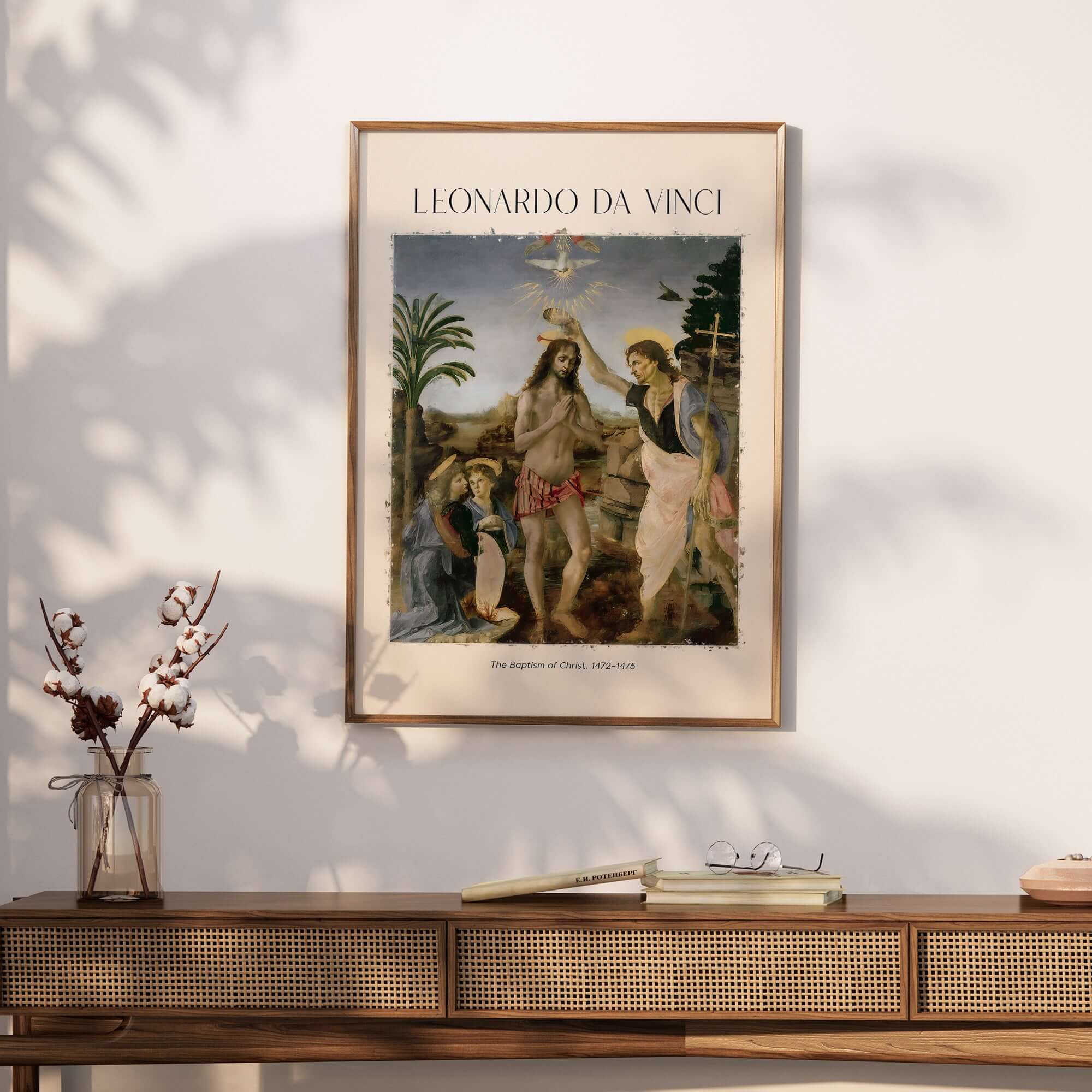 Leonardo da Vinci Art Print The Baptism of Christ 1470s displayed on a wall above a stylish wooden table with decor.