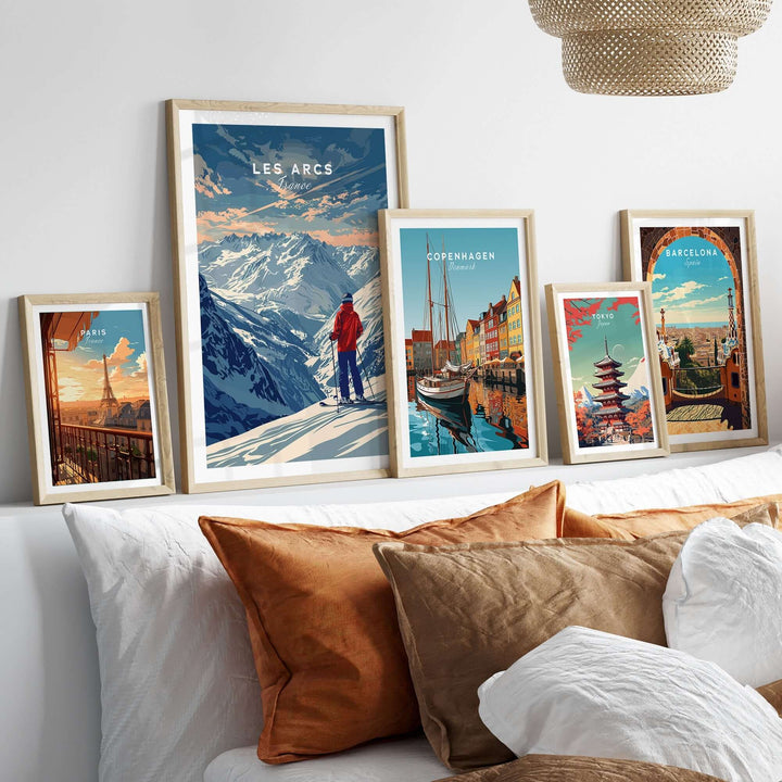 Les Arcs travel poster and various city posters displayed above a stylish bed with decorative pillows.