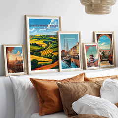 Lincolnshire Wolds Travel Poster displayed among various travel posters on a stylish bed with decorative pillows.