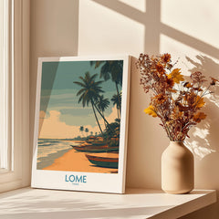 Lomé Togo Canvas Print | Palm Trees & Ocean View Poster displayed next to a vase with dried flowers.