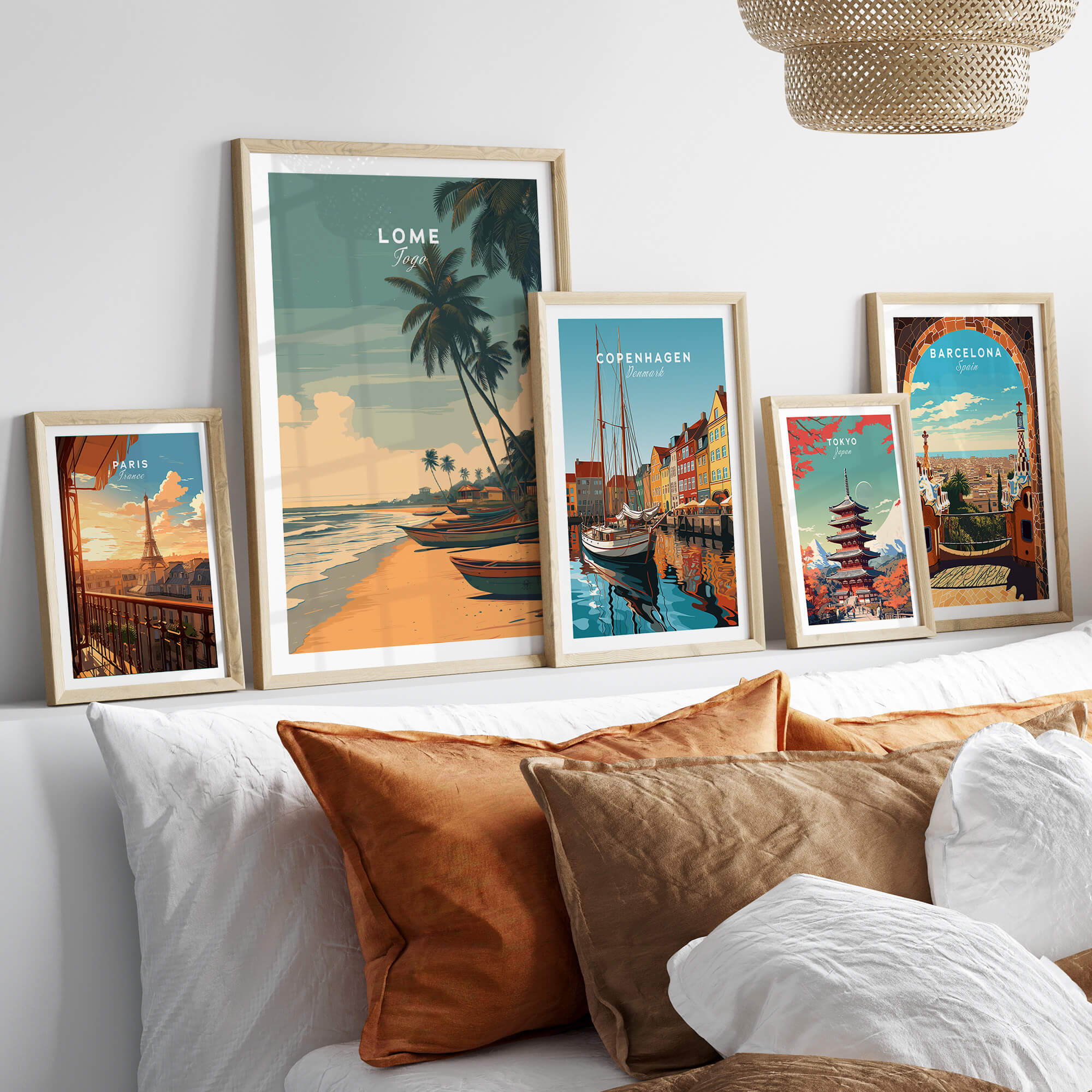 Lomé Togo Travel Poster | Sunset Shoreline Wall Art Print displayed among other travel posters on a stylish couch.