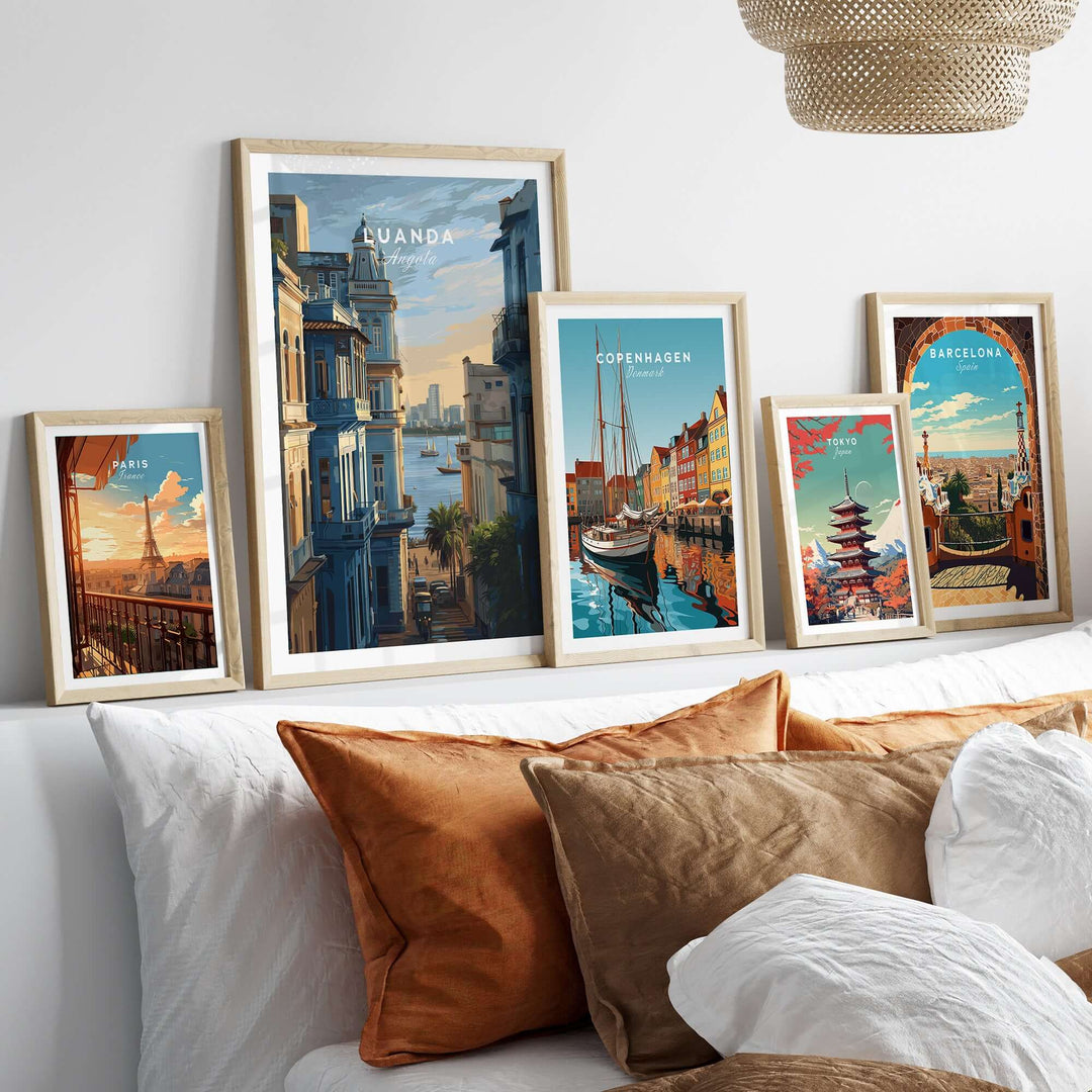 Framed cityscape posters of Luanda, Copenhagen, Barcelona on a wall above a stylish couch.