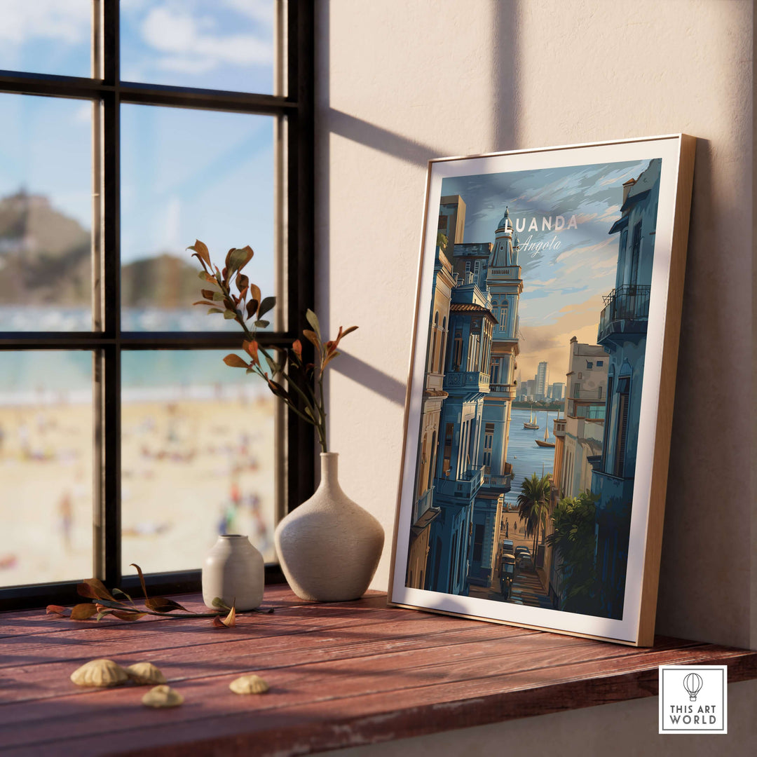 Luanda cityscape poster displayed on a wooden table near a beach view, adding vibrant coastal decor to the room.