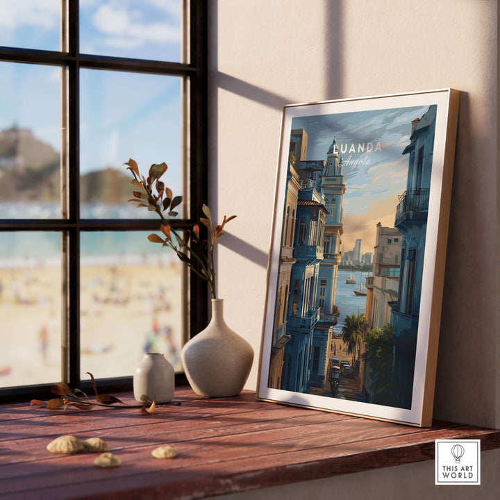 Luanda cityscape poster displayed on a wooden table near a beach view, adding vibrant coastal decor to the room.