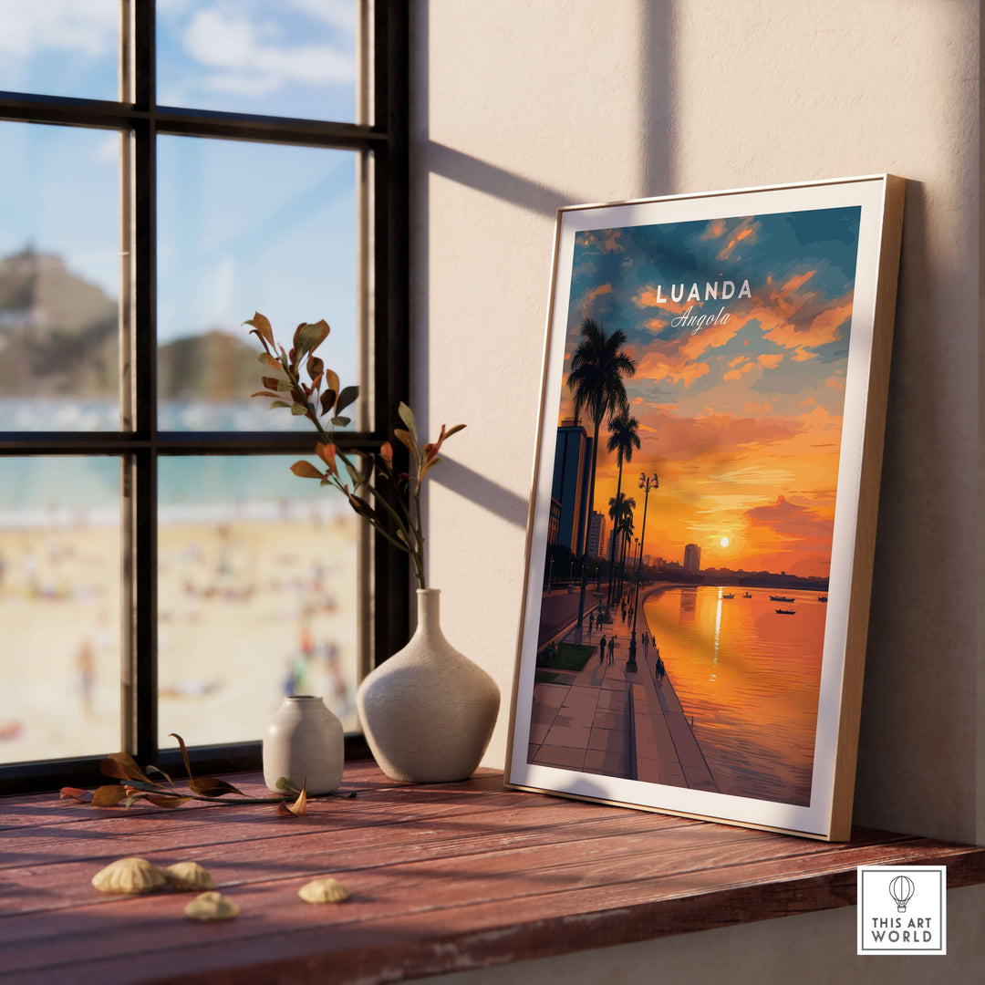 Luanda City at dusk print framed on a wooden table with beach view, showcasing vibrant sunset and palm trees.