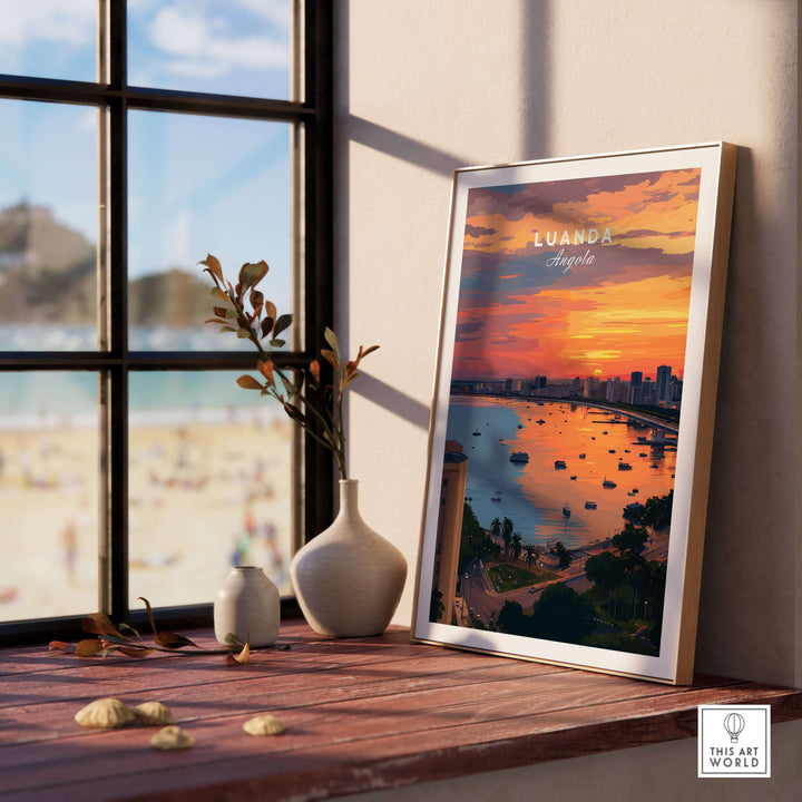 Luanda skyline sunset poster displayed on a wooden table near a window, showcasing vibrant colors and waterfront view.