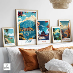 Lugano Poster Switzerland displayed among other travel posters on a stylish shelf, showcasing beautiful landscapes.
