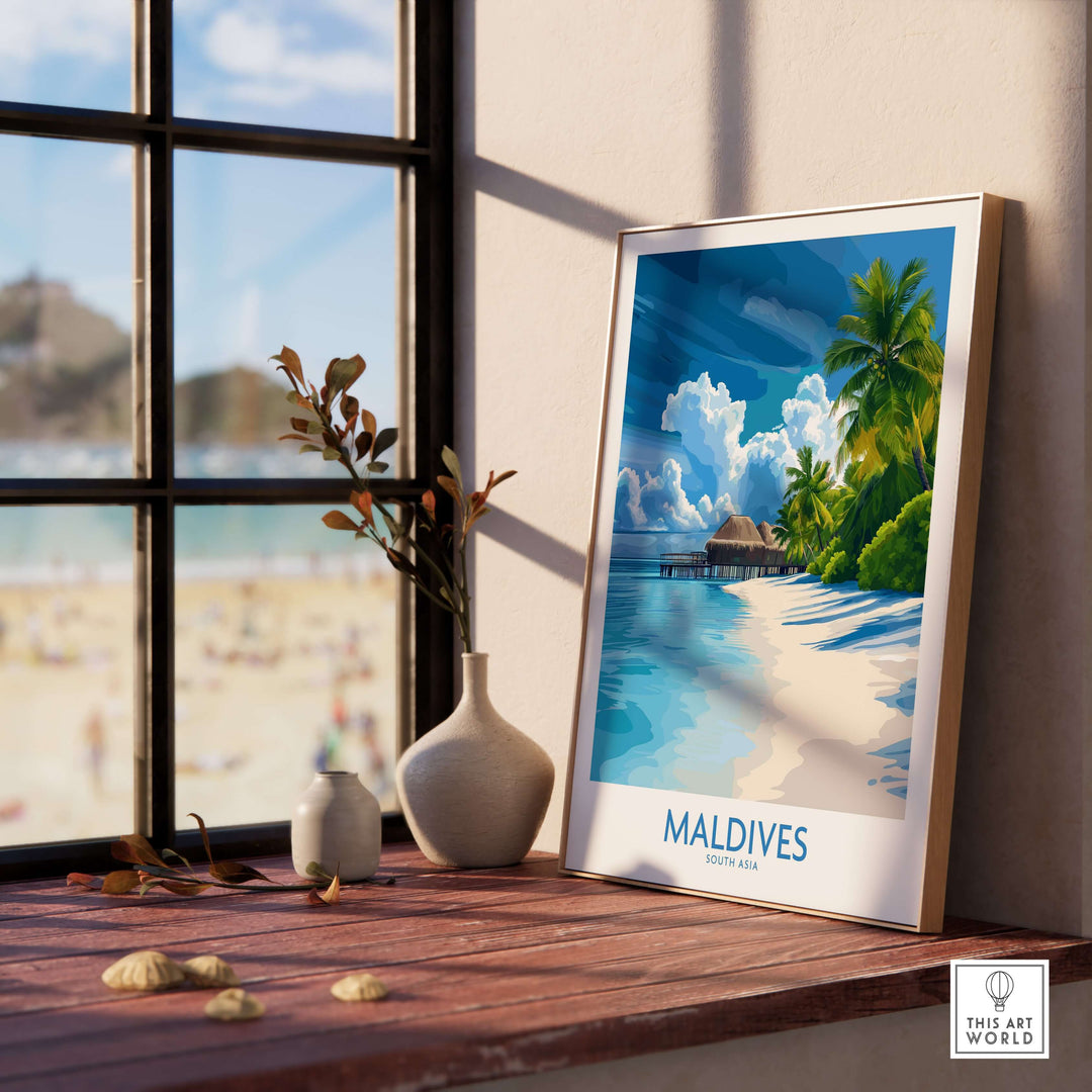 Maldives Wall Art Print - Tropical Beach displayed on a wooden table by a window overlooking a sandy beach.