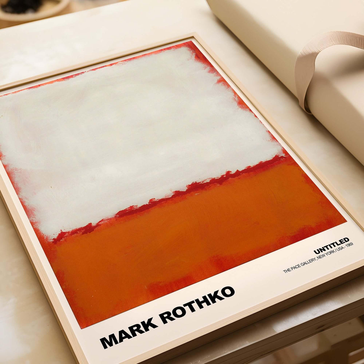 Mark Rothko Untitled 1969 Abstract Expressionism Poster White Orange Color Field Print framed on a table.