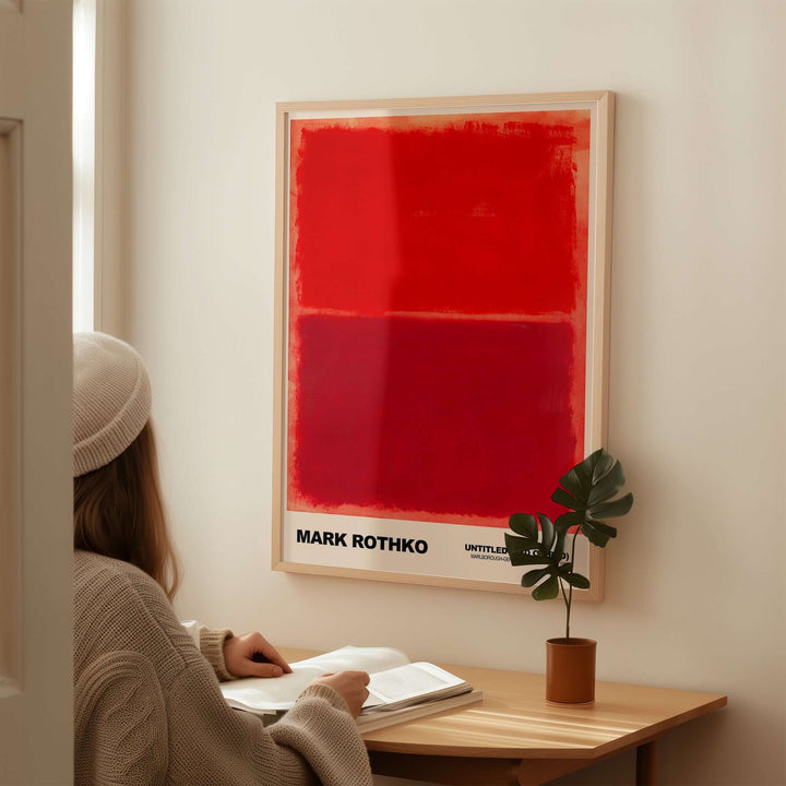 Mark Rothko Untitled Red on Red 1969 abstract art print displayed on wall, with a person reading at a desk.
