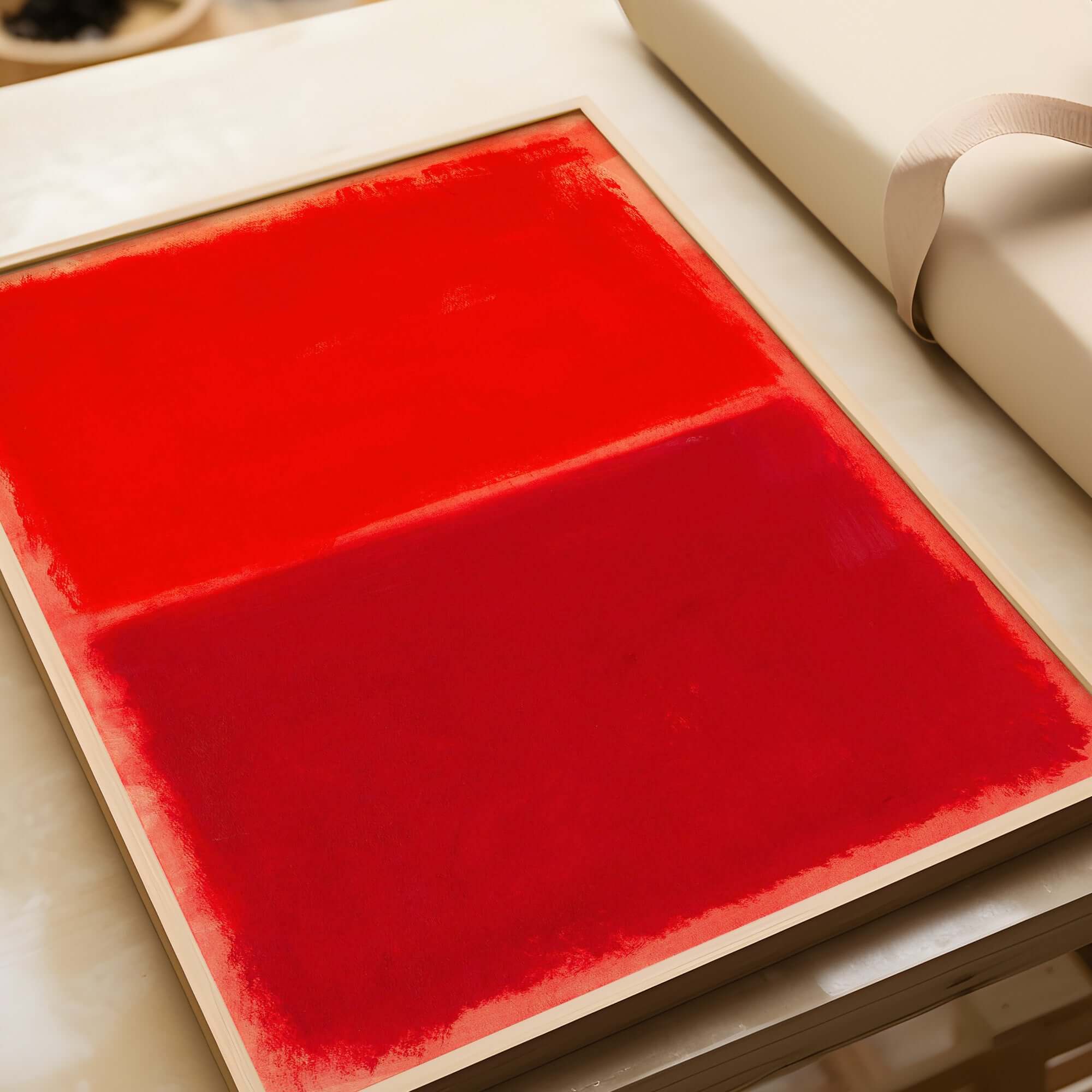 Mark Rothko Untitled Red on Red 1969 Abstract Canvas Art Print displayed on a table, showcasing vibrant crimson tones.