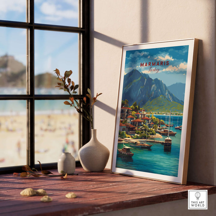 Marmaris poster featuring sailboats and mountains, displayed by a sunny window, evoking Turkey's coastal beauty.
