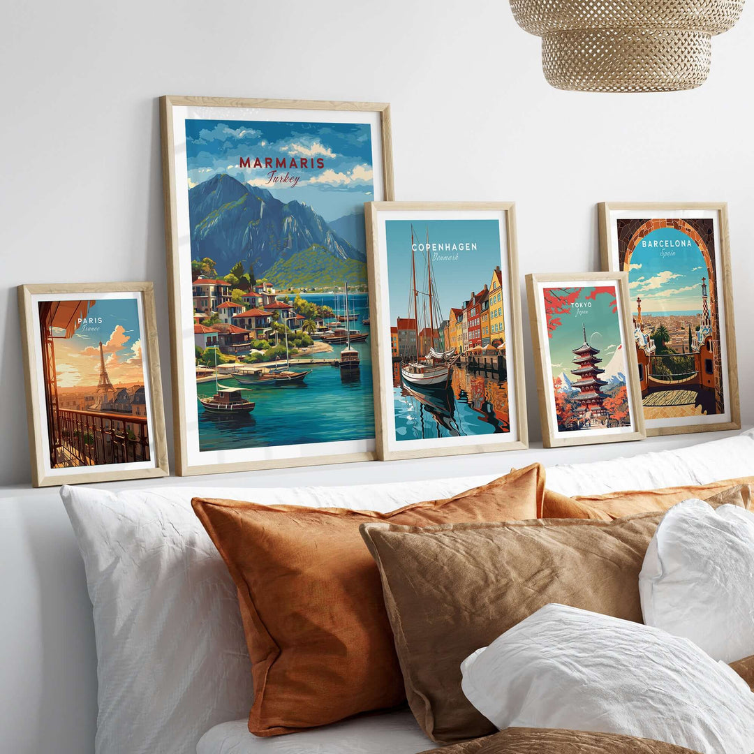 Framed travel posters of Marmaris, Copenhagen, and Barcelona displayed on a cozy sofa with decorative pillows.