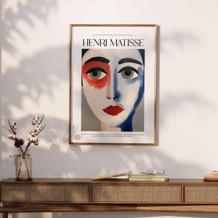 Henri Matisse abstract face portrait print in a modern frame on a stylish table with decorative flowers.
