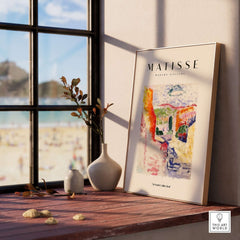 Matisse Art Prints - Abstract Fauvist Poster displayed on a wooden ledge by a sunny window with beach view.